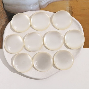 Detail view of 34mm cream round resin cabochons with pearl luster for DIY jewelry making