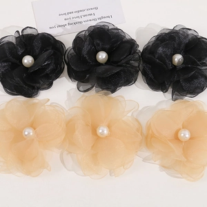Detailed view of layered organza flowers with pearl beads for DIY hair accessories