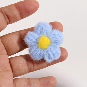 Detailed shot of handmade crochet plush blue flower with yellow center for DIY crafts