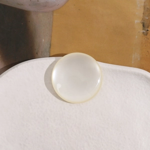 Detailed macro view of 34mm cream round resin cabochon with mother of pearl luster