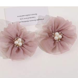 Close-up of pink organza flower hair clips with central pearls and sparkling rhinestones