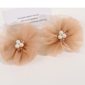 Detail of beige mesh gauze flower hair clips with elegant pearls and sparkling rhinestones