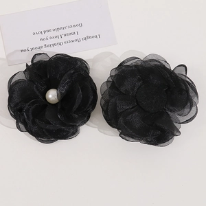 Detailed view of layered black mesh flower hair accessories with faux pearl centerpiece