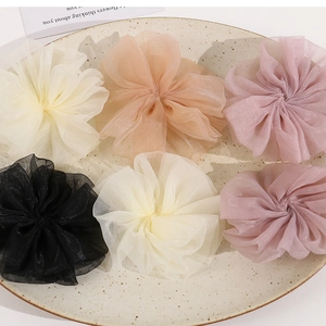 Close-up of layered pleated organza mesh flower hair scrunchies in pastel colors
