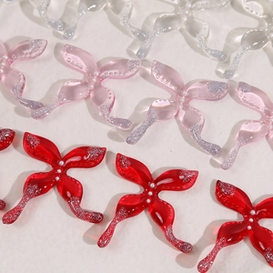 Detail van glitterende hars vlinderbedeltjes met witte parels voor DIY-sieraden