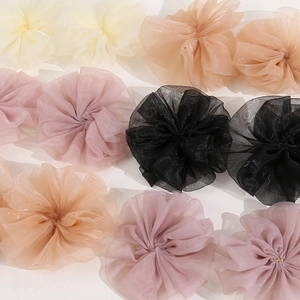 Close-up of layered pleated mesh flower hair scrunchies in cream, pink and black