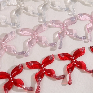 Detail van harsbloem bedeltjes met glitterranden en parels voor DIY-sieraden