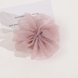 Detail of light pink pleated mesh fabric flower scrunchie with soft transparent texture
