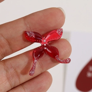 Macro-opname van een rode vlinder van hars met zilveren glitters en kleine parels