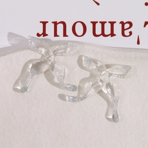 Macro-opname van transparante vlinderbedeltjes van hars met glitter en pareldetails