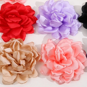 Detailed view of multi-layered fabric camellia flowers in various vibrant satin colors