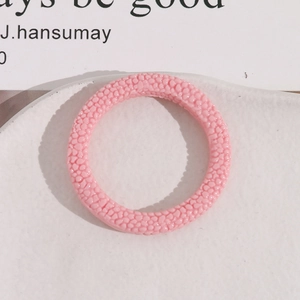 Makroaufnahme von rosa strukturierten Harzohrringen mit einer einzigartigen körnigen Oberfläche