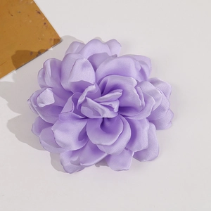 Detailed macro view of a multi-layer purple satin camellia flower fabric accessory