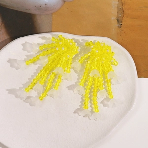 Macro view of handmade yellow glass beaded tassels with lily of the valley pendants