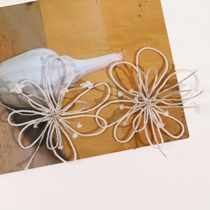 Detail of handcrafted white beaded flower hair accessories with glass beads and pearls