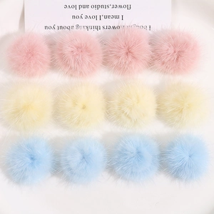 Detailopname van 3 cm kleurrijke pluche pompons in pastelroze, geel en blauw