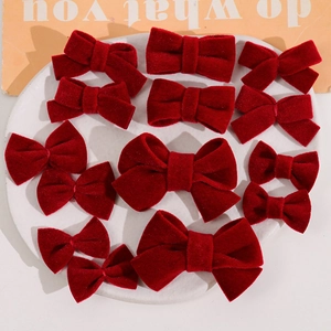 Detailed view of dark red velvet bow hair accessories in various sizes on a tray