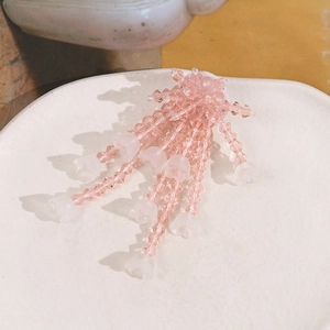 Detail of pink crystal beads and lily of the valley tassels on a handmade hair accessory