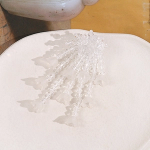 Detailed macro view of handmade lily of the valley beaded tassels on ceramic plate