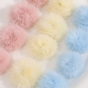 Macro-opname van 3cm zachte pluche pompons in roze, geel en blauw voor DIY-accessoires