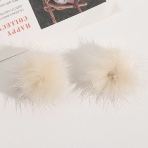Detail von flauschigen 3,5cm beigen Kunstfell-Pompons für DIY-Schmuck und Haarschmuck