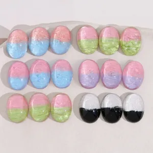 Close-up of dual-color gradient oval resin patches with glitter for DIY jewelry making
