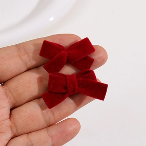 Close-up of two handmade burgundy velvet bow hair clips with soft flocked texture