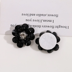 Dettaglio macro di fiori in cristallo nero con base in feltro bianco per gioielli DIY