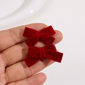 Close-up of a pair of handmade red velvet hair bows showing soft texture and size