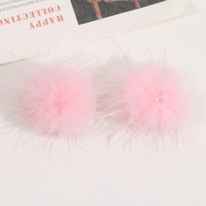 Nahaufnahme von zwei rosa Plüsch-Pompons aus Kunstfell für DIY-Kleidung und Haarschmuck
