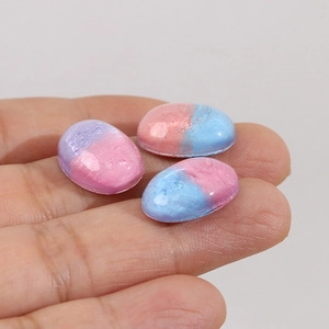 Close-up of oval resin cabochons with blue and purple pearlescent marble texture