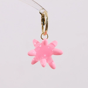 Detailed view of creative pink star-shaped sea urchin pendant with golden metal hoop earring