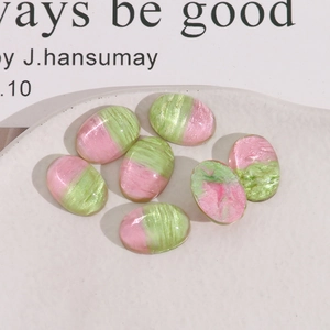Macro shot of oval bicolor pink and green resin cabochons with pearl texture for DIY crafts