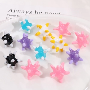 Close-up of colorful resin star-shaped sea urchin beads in a ceramic tray