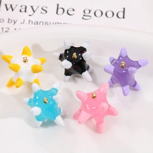 Colorful star-shaped resin charms with glossy finish and gold loops for DIY jewelry
