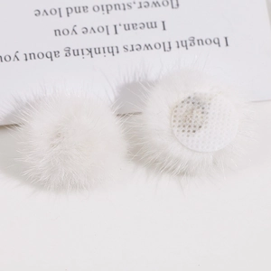 Detailopname van witte 3cm nertsbont pompons met netbasis voor DIY-sieraden en handwerk
