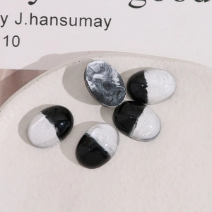 Macro detail of oval resin patches with black and silver marble texture for DIY accessories