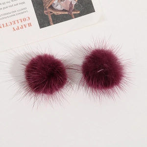 Nahaufnahme von flauschigen dunkelroten Nerzfell-Pompons für DIY-Haarschmuck
