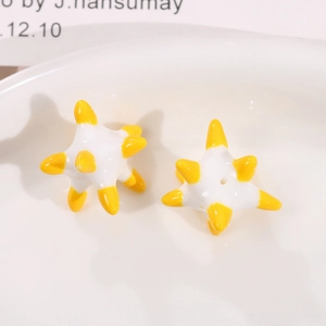 Macro view of bicolor star-shaped resin beads in white and yellow for DIY jewelry