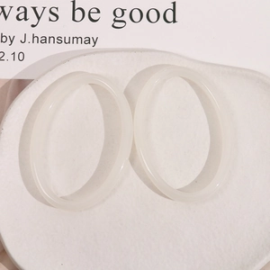 Macro shot of minimalist translucent resin oval hollow earrings on a ceramic display plate
