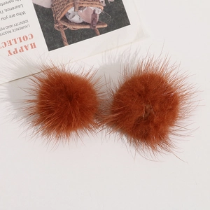 Nahaufnahme von zwei braunen Nerzfell-Pompons für DIY-Haarschmuck und Kleidung