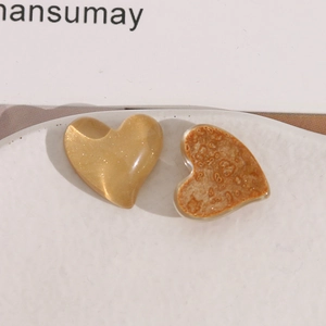 Macro detail of heart-shaped resin jewelry accessories with amber texture and gold finish
