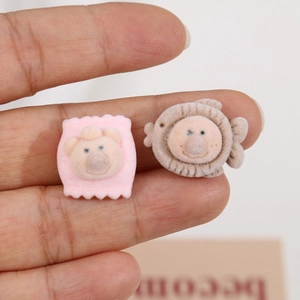 Macro detail of mini flocked cartoon bear and lion charms for DIY craft accessories