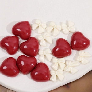 Breloques en résine cœur rouge et nœud blanc pour bijoux DIY sur plateau