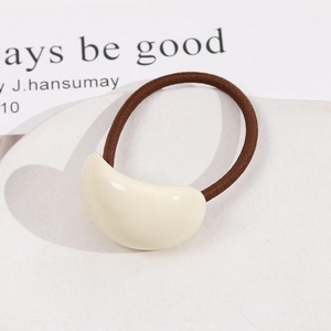 Élastique à cheveux minimaliste avec perle en acrylique crème sur un plateau blanc