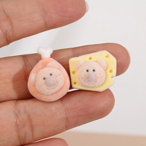 Detail of cute flocked pig head charms on cheese and chicken leg shapes for DIY crafts