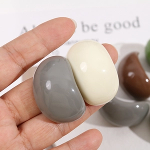 Gros plan d'accessoires en résine en forme de haricot aux tons terreux brillants