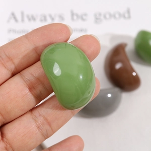 Gros plan d'un pendentif ovale en résine verte polie pour la création de bijoux DIY à la main