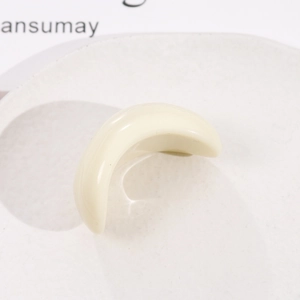 Vue macro d'un accessoire en résine blanc crème en forme de croissant poli brillant