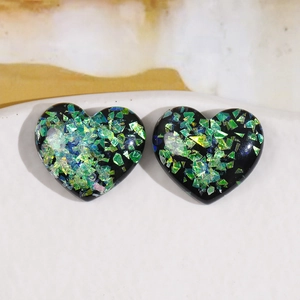 Glittering heart-shaped resin DIY accessories with green and blue sequins on white tray